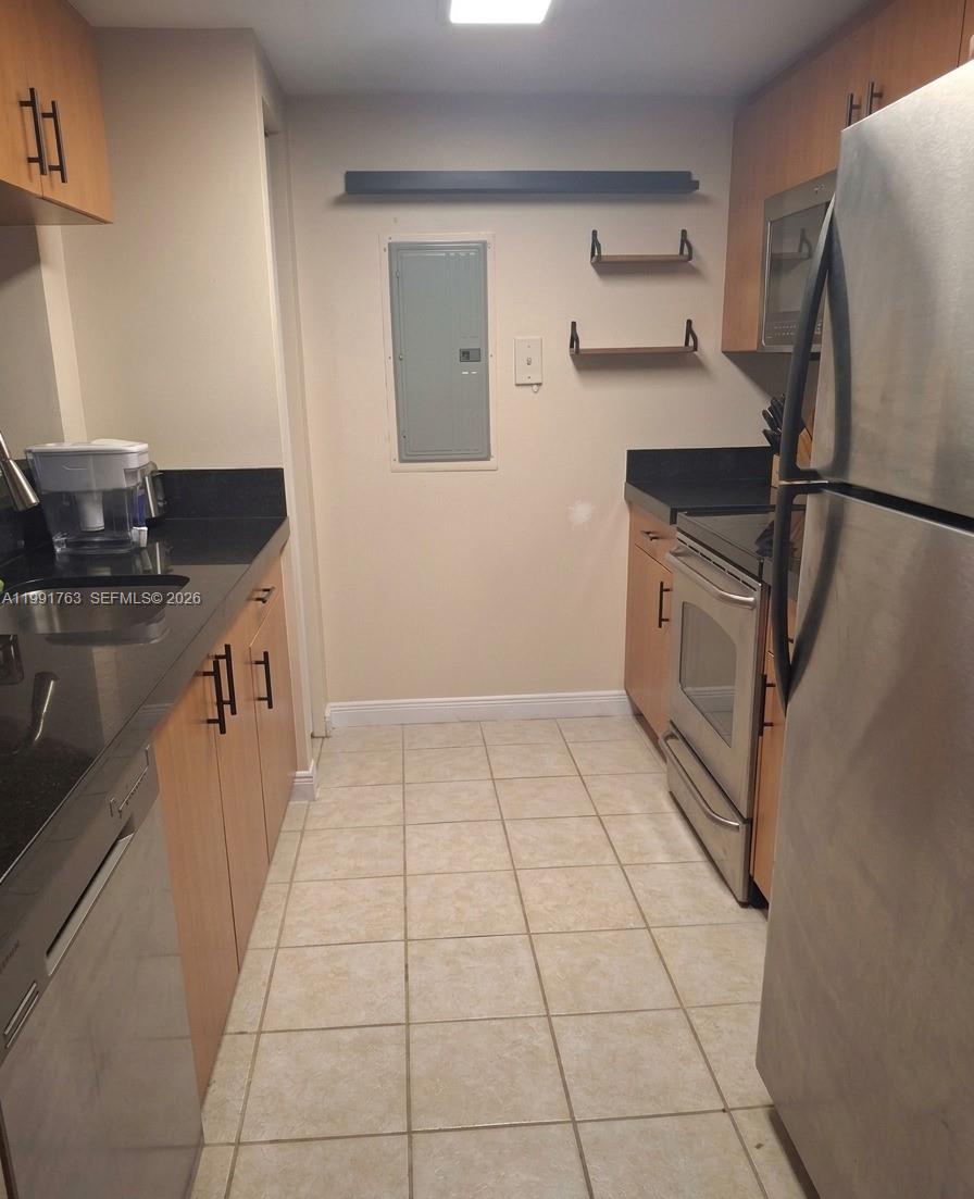 816 Northwest 11th Street, Unit 806 Miami, FL 33136 - Photo 3 of 12 a kitchen with granite countertop a refrigerator and a stove top oven