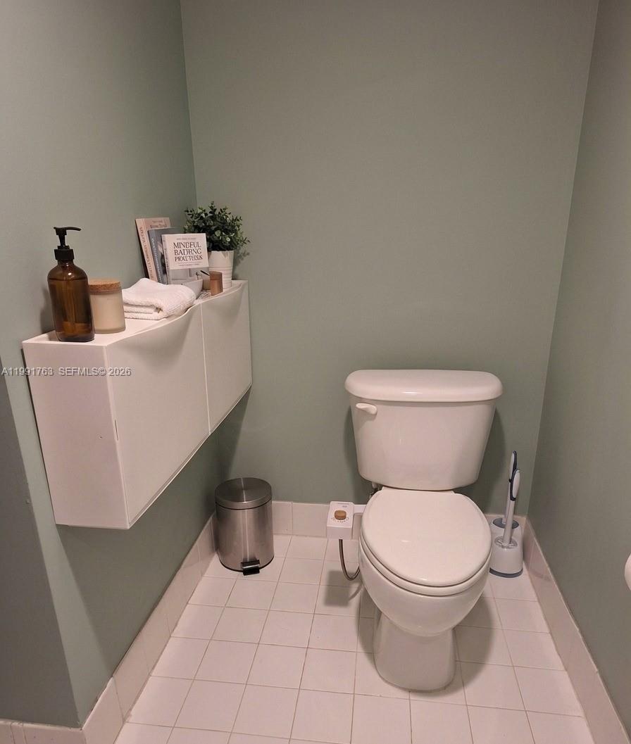 816 Northwest 11th Street, Unit 806 Miami, FL 33136 - Photo 5 of 12 a white toilet sitting next to a bathroom sink and a granite counter