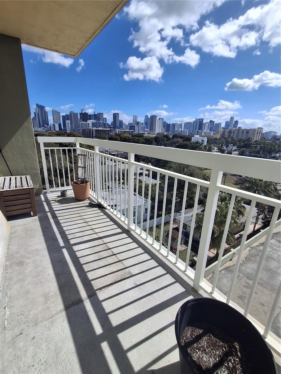 816 Northwest 11th Street, Unit 806 Miami, FL 33136 - Photo 10 of 12 a view of a balcony with wooden floor and city view