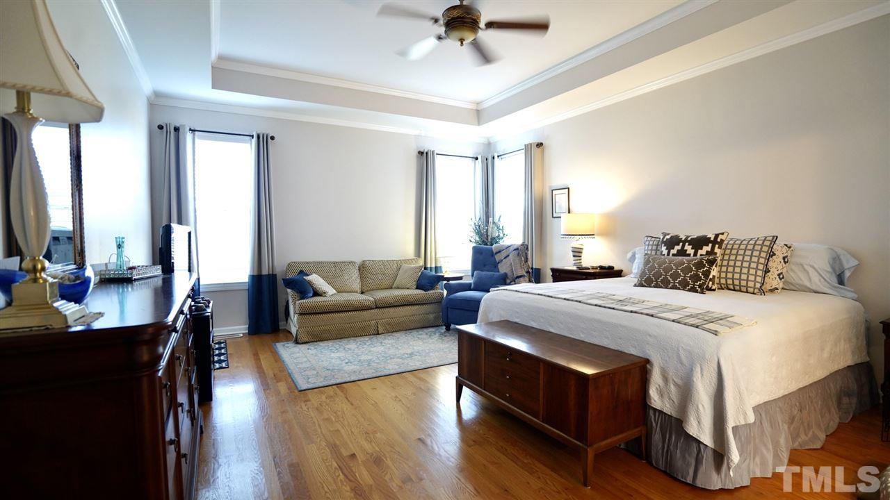 116 Okamato Street Raleigh, NC 27603 - Photo 12 of 19 a spacious bedroom with a bed a couch and a dresser in it