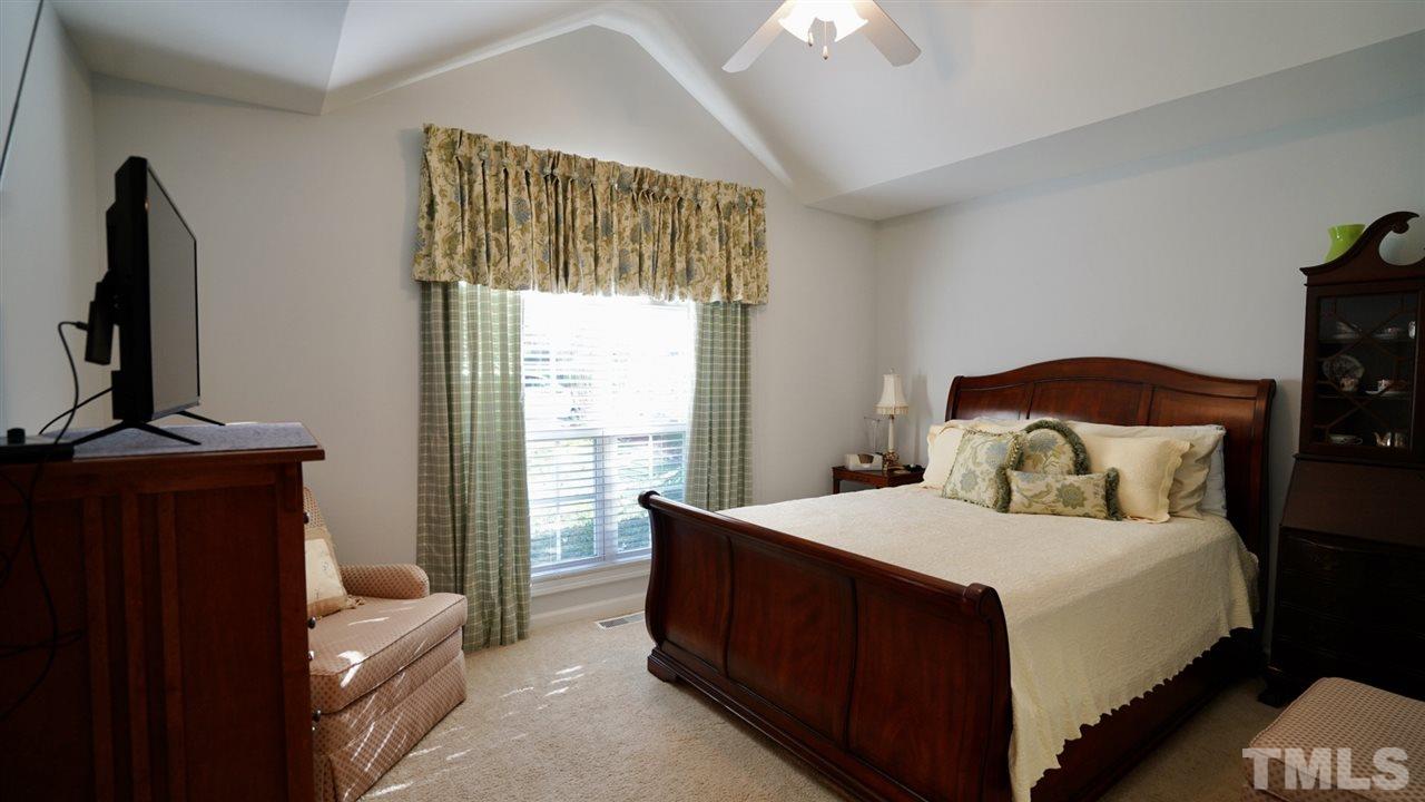 116 Okamato Street Raleigh, NC 27603 - Photo 14 of 19 a bedroom with a bed and a flat tv screen on dresser