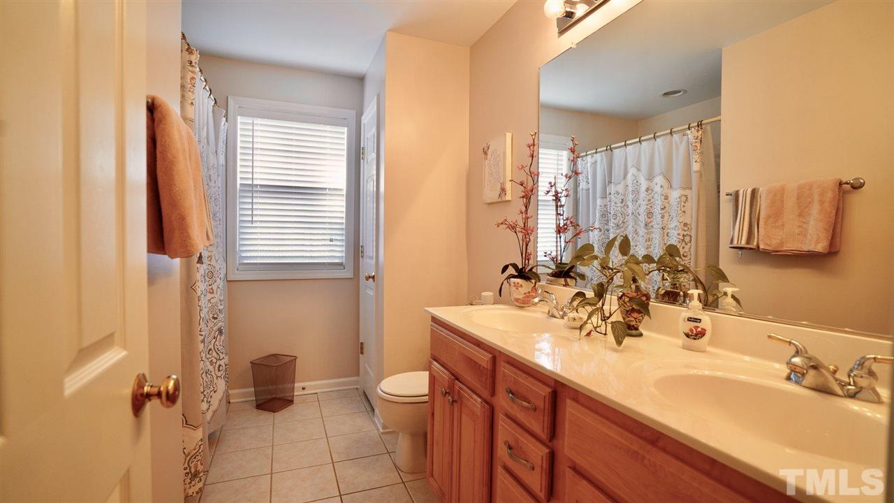 116 Okamato Street Raleigh, NC 27603 - Photo 15 of 19 a bathroom with a double vanity sink a mirror and a shower