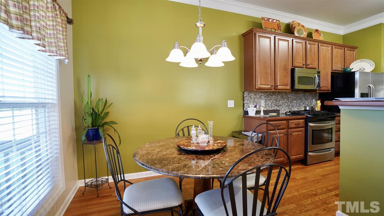 116 Okamato Street Raleigh, NC 27603 - Photo 9 of 19 a kitchen with a table chairs a sink and a stove