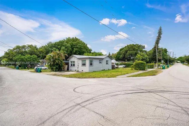 a view of a house with a yard and a basketball court