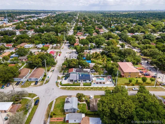 an aerial view of residential houses with outdoor space and swimming pool