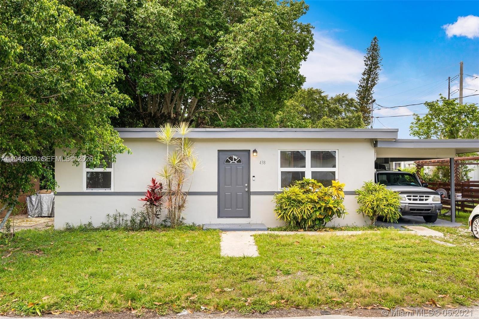 438 Northwest 93rd Street, Unit 440 Miami, FL 33150 - Photo 6 of 13 front view of a house with a yard