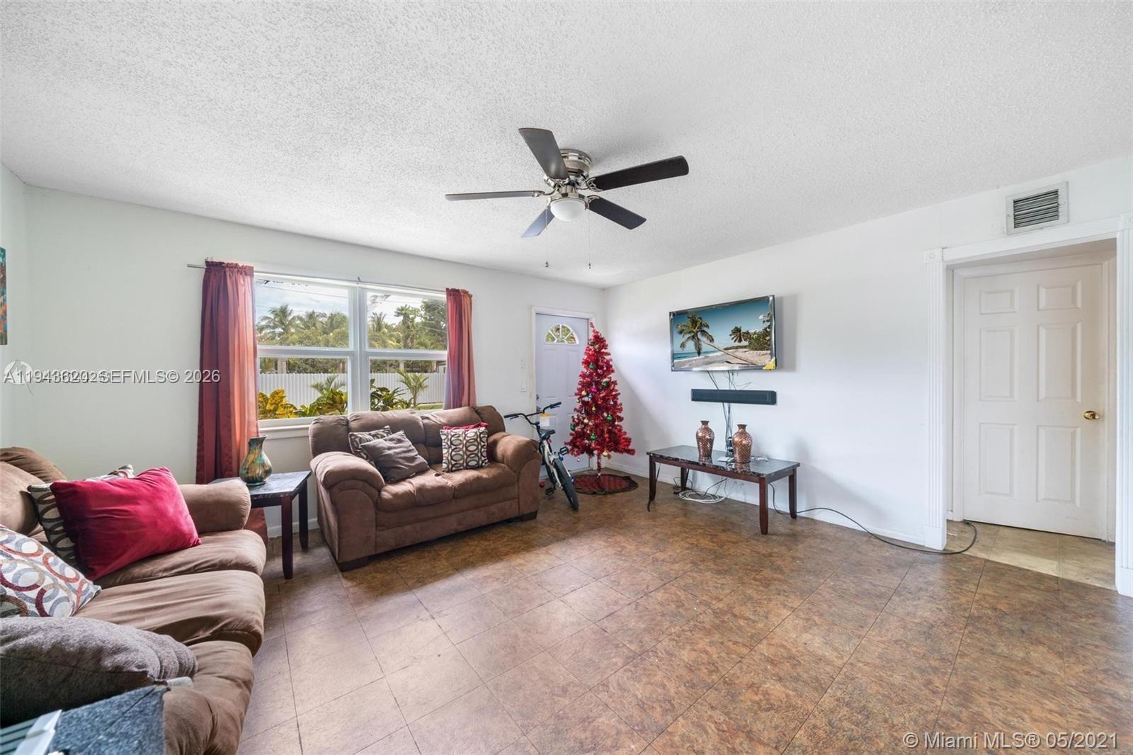 438 Northwest 93rd Street, Unit 440 Miami, FL 33150 - Photo 7 of 13 a living room with furniture and a window