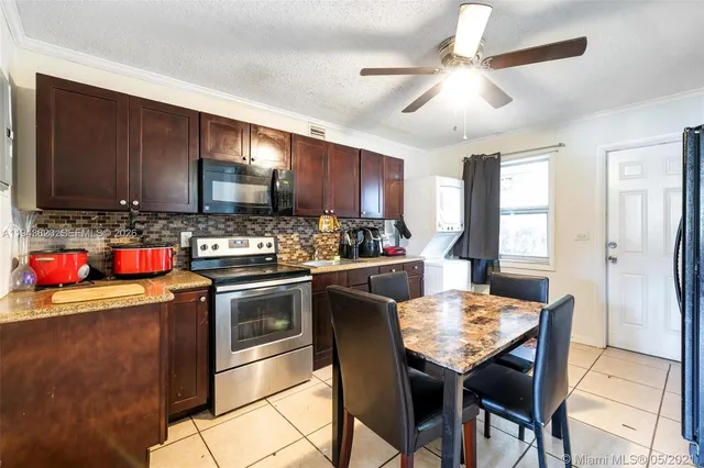 a kitchen with granite countertop wooden cabinets a stove a sink and a refrigerator