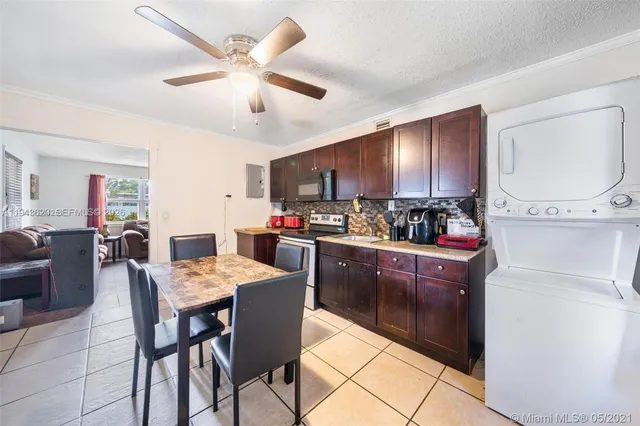 a kitchen with granite countertop cabinets stainless steel appliances and a dining table