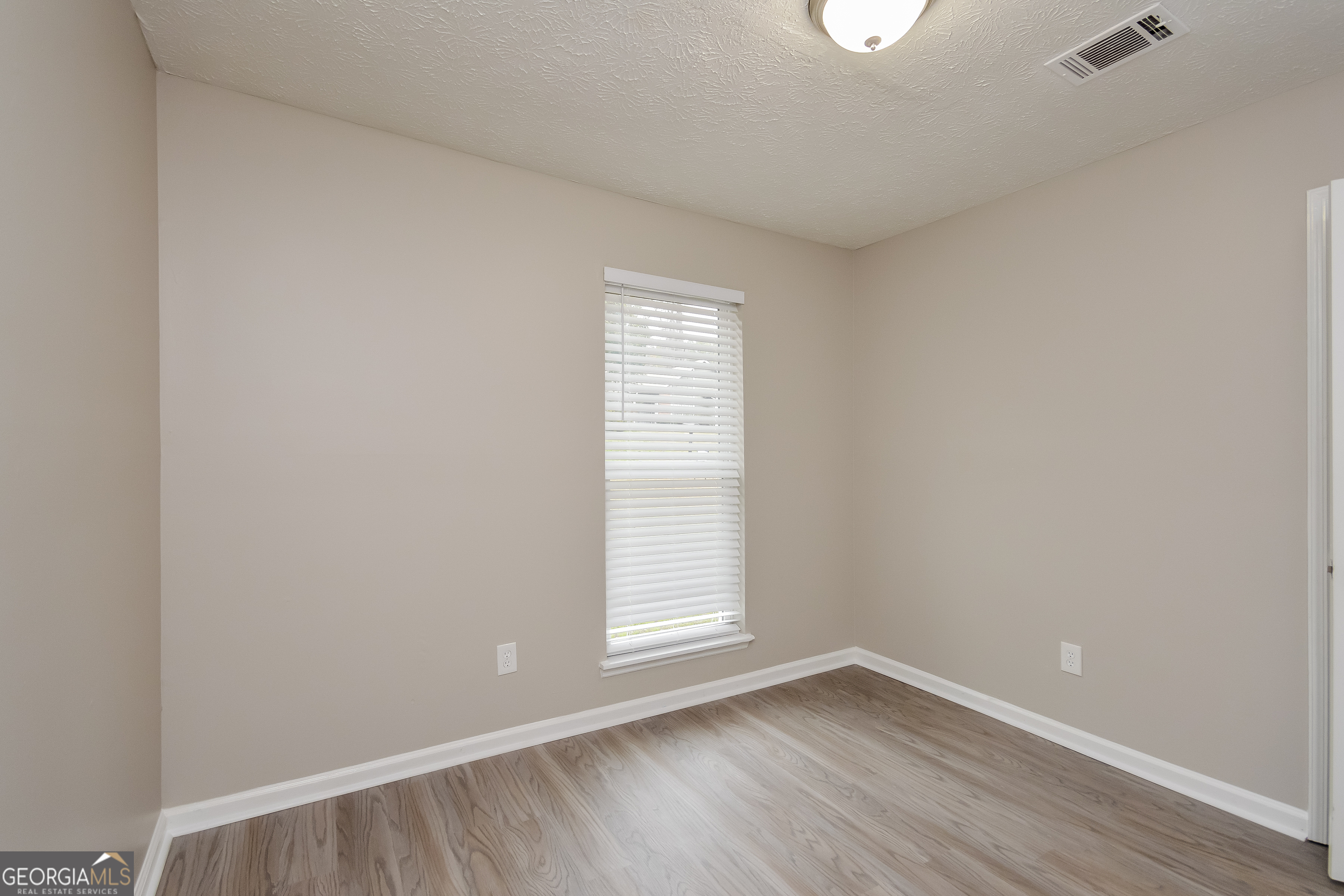 5456 Panola Downs Road Lithonia, GA 30058 - Photo 11 of 16 a view of an empty room with wooden floor and a window