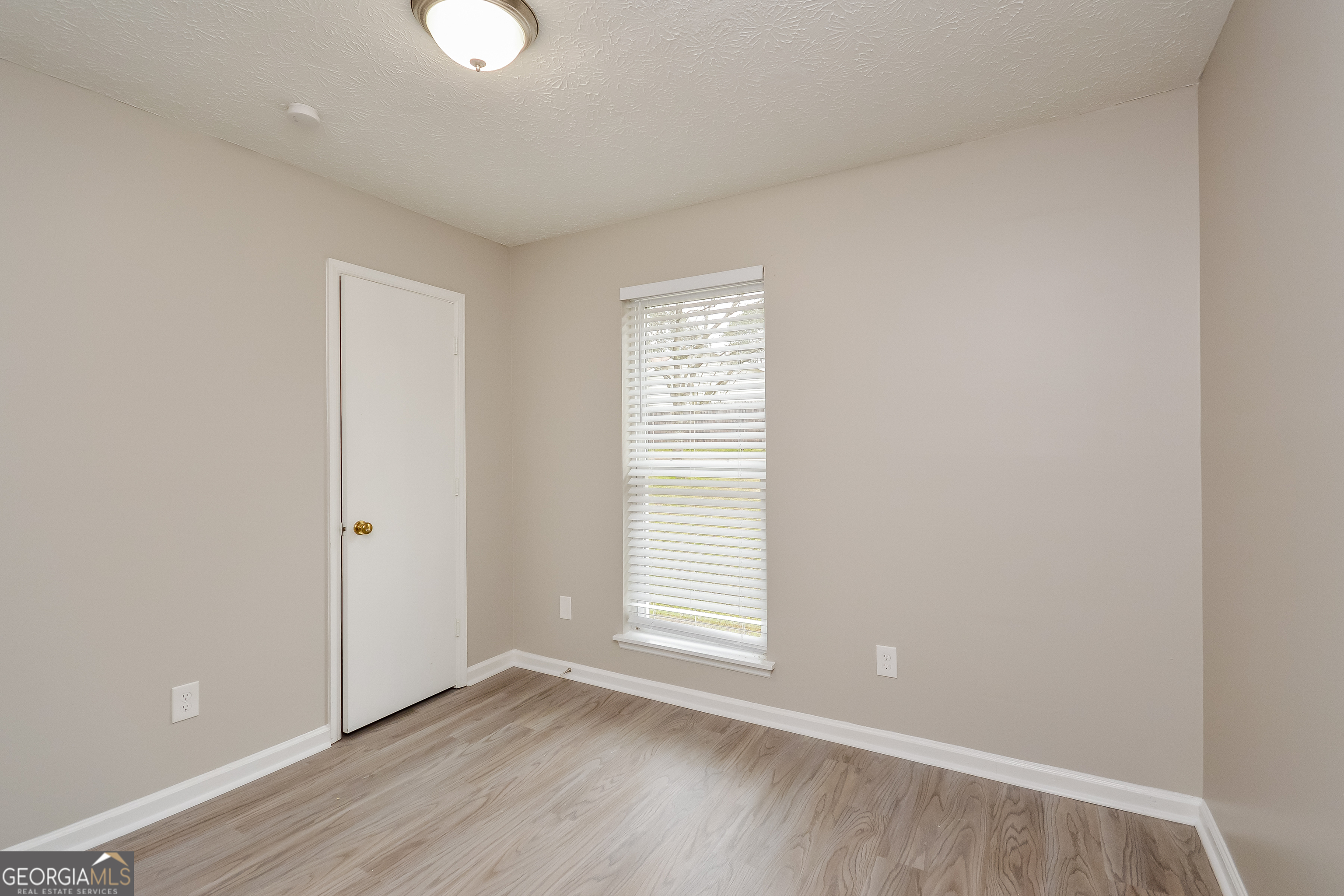 5456 Panola Downs Road Lithonia, GA 30058 - Photo 14 of 16 an empty room with wooden floor and windows