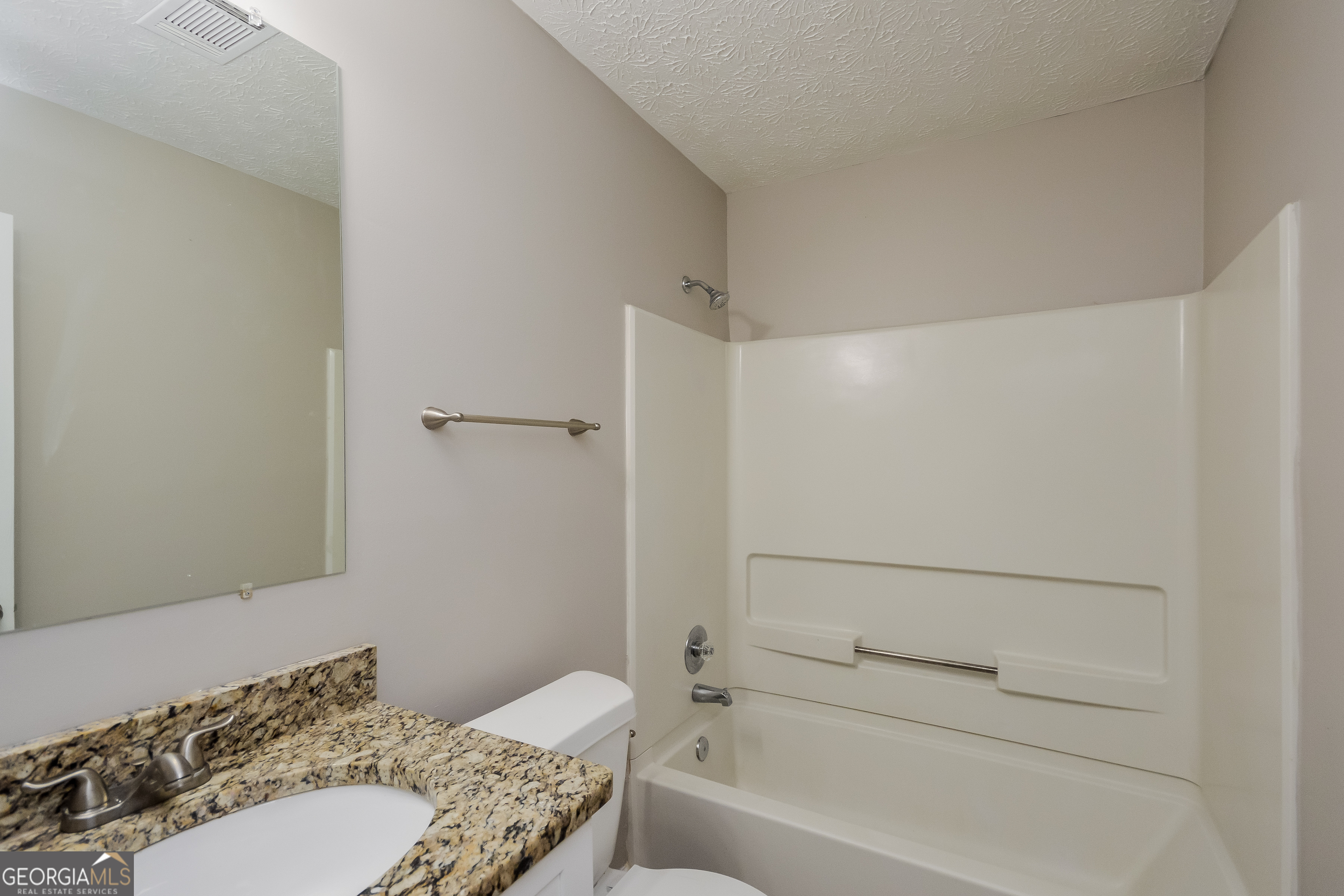 5456 Panola Downs Road Lithonia, GA 30058 - Photo 15 of 16 a bathroom with a granite countertop sink a toilet and shower