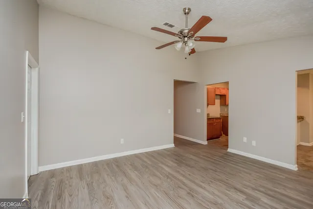 a view of a room with wooden floor and a ceiling fan