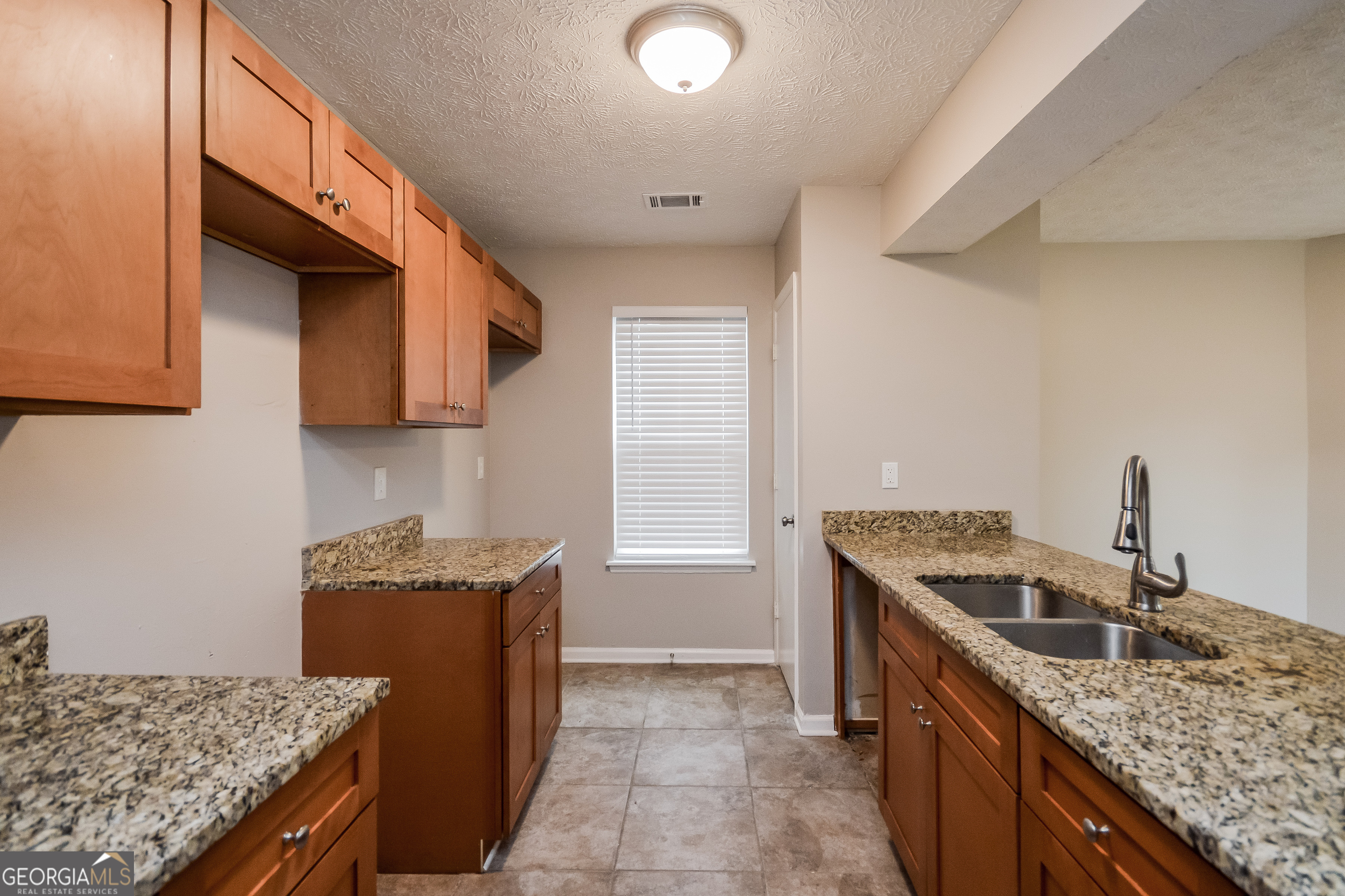 5456 Panola Downs Road Lithonia, GA 30058 - Photo 6 of 16 a kitchen with granite countertop a sink a stove and a wooden cabinets