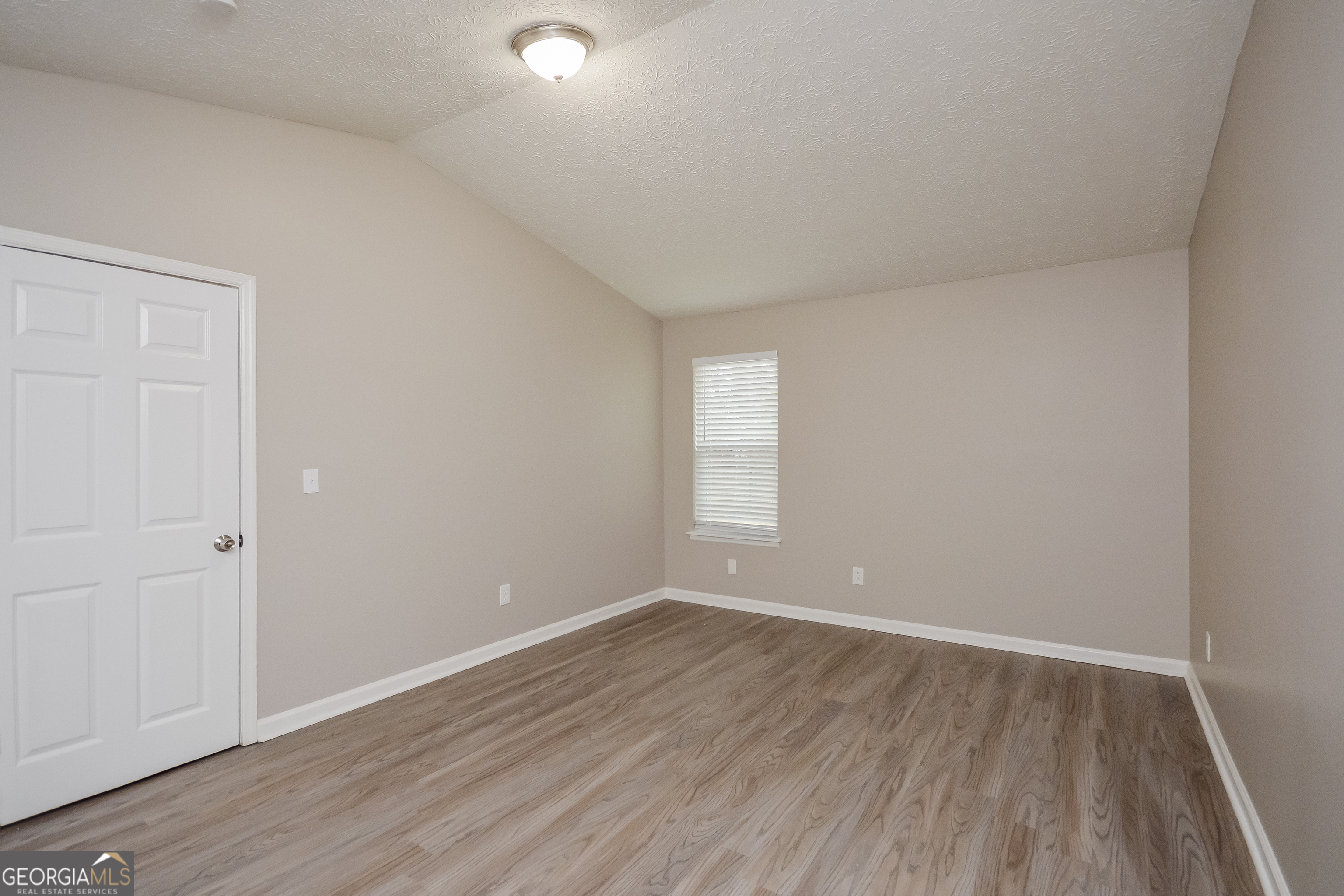 5456 Panola Downs Road Lithonia, GA 30058 - Photo 8 of 16 a view of an empty room with wooden floor and a window