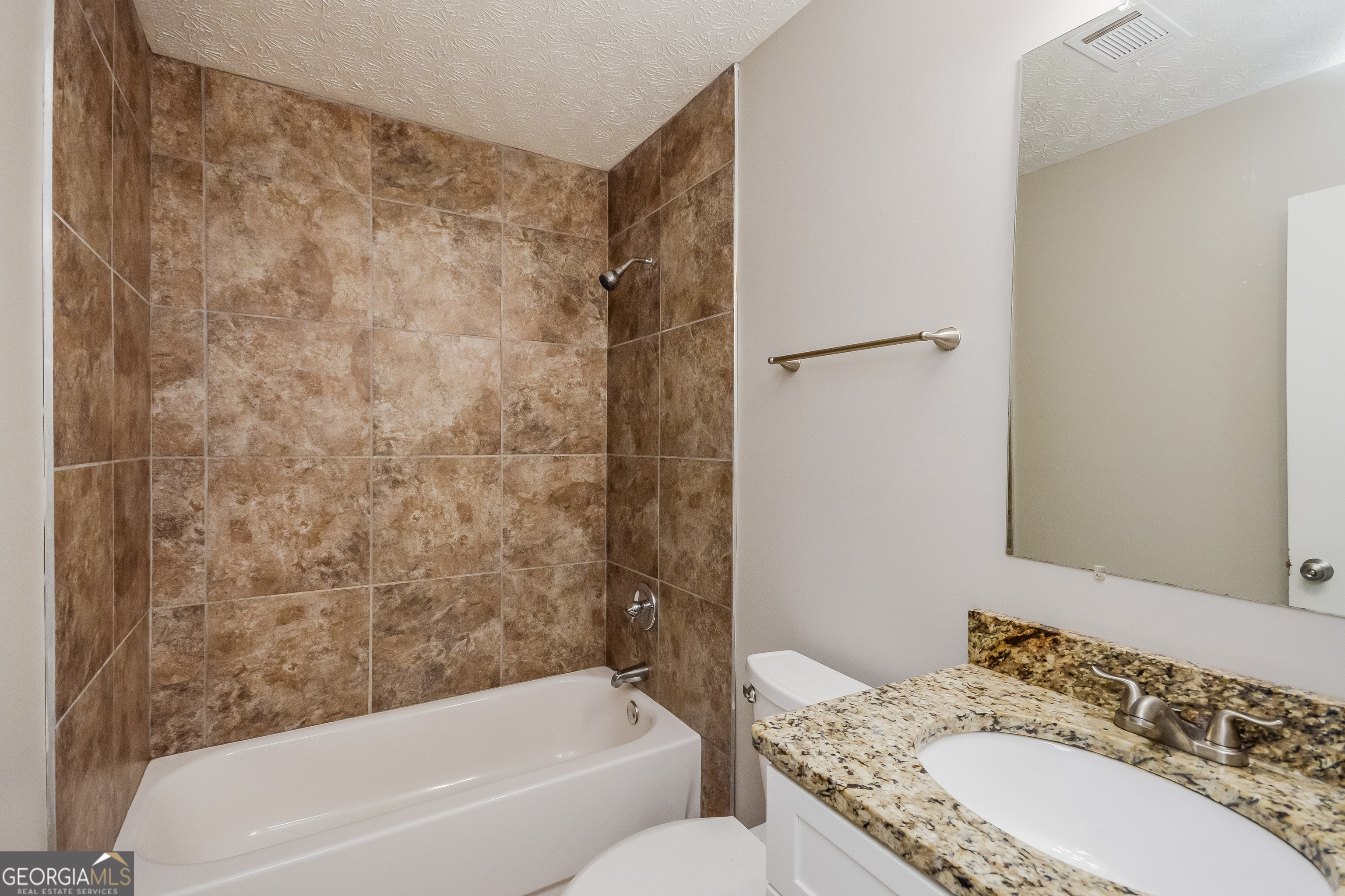 5456 Panola Downs Road Lithonia, GA 30058 - Photo 10 of 16 a bathroom with a granite countertop sink and a bathtub