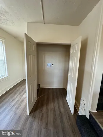 an empty room with wooden floor and entrance