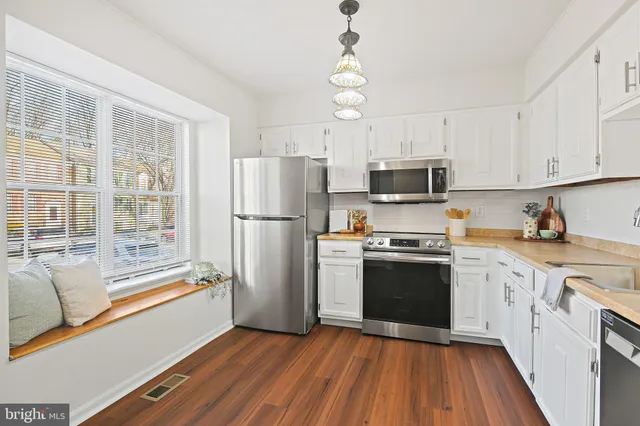 a kitchen with wooden floors and stainless steel appliances