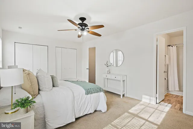 a spacious bedroom with a bed a dresser and potted plants