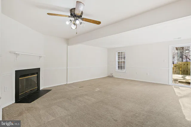 a view of a livingroom with a fireplace and a chandelier fan
