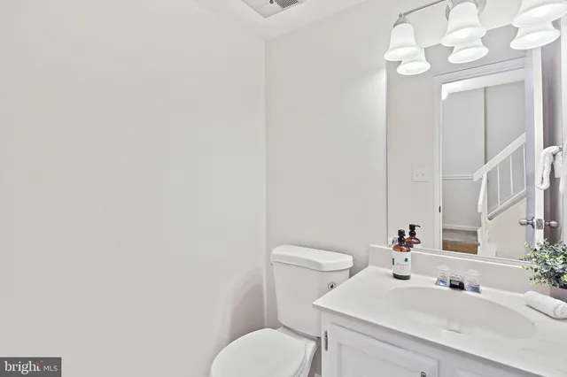 a bathroom with a sink vanity mirror and toilet
