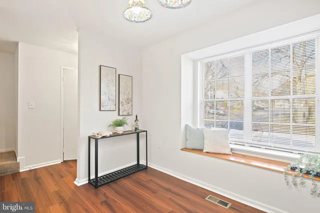 a living room with a window and wooden floor