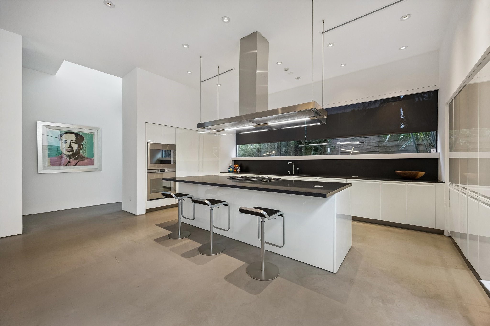 1527 Indiana Street Houston, TX 77006 - Photo 10 of 30 The chef's kitchen features sleek Poliform cabinetry, granite counters with a bookmatched backsplash, and Gaggenau appliances.