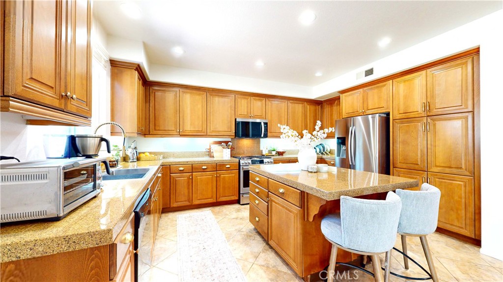 1279 Longbranch Road San Jacinto, CA 92582 - Photo 7 of 35 a kitchen with stainless steel appliances granite countertop sink stove refrigerator and cabinets