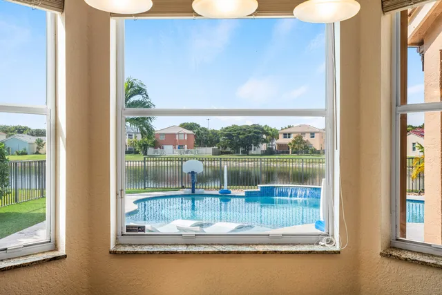a dining room with wooden floor a chandelier a wooden table and chairs