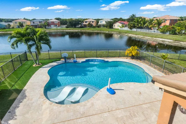 an aerial view of a city with lots of residential buildings ocean and mountain view in back