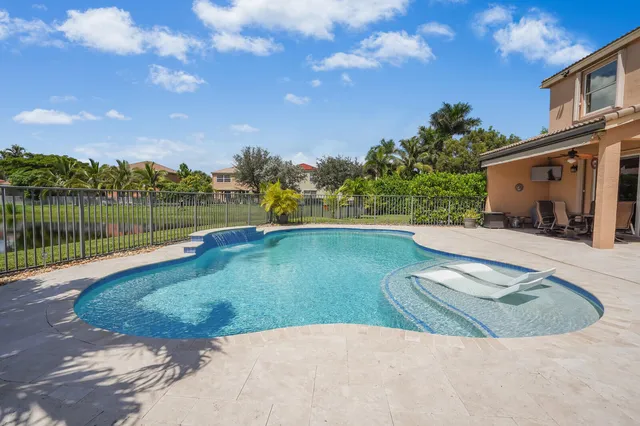 an aerial view of a residential houses with outdoor space and lake view