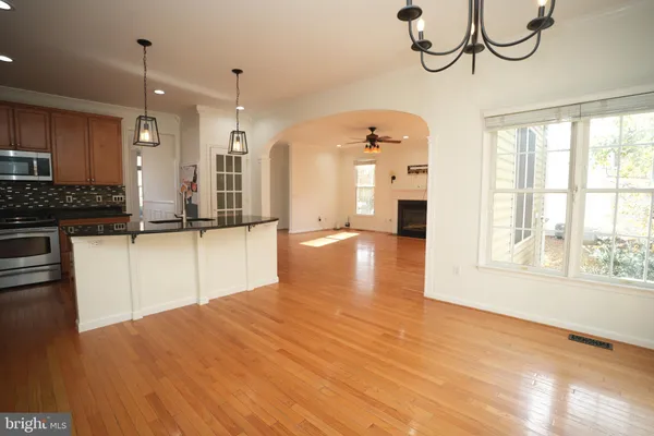 a view of a kitchen with granite countertop a window and a wooden floor