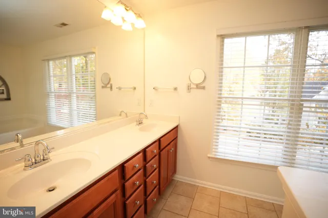 a bathroom with a granite countertop sink and a large mirror