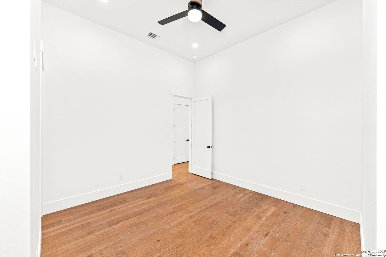 1202 Cielo Rio Drive Pipe Creek, TX 78063 - Photo 36 of 54 an empty room with a ceiling fan and wooden floor