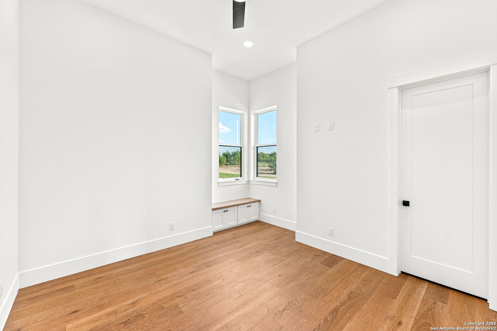 1202 Cielo Rio Drive Pipe Creek, TX 78063 - Photo 38 of 54 an empty room with wooden floor and windows