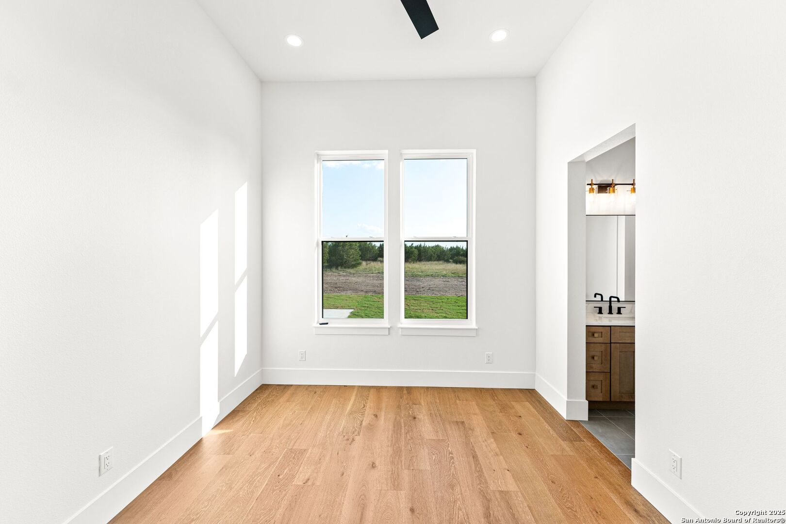 1202 Cielo Rio Drive Pipe Creek, TX 78063 - Photo 40 of 54 an empty room with wooden floor and a window