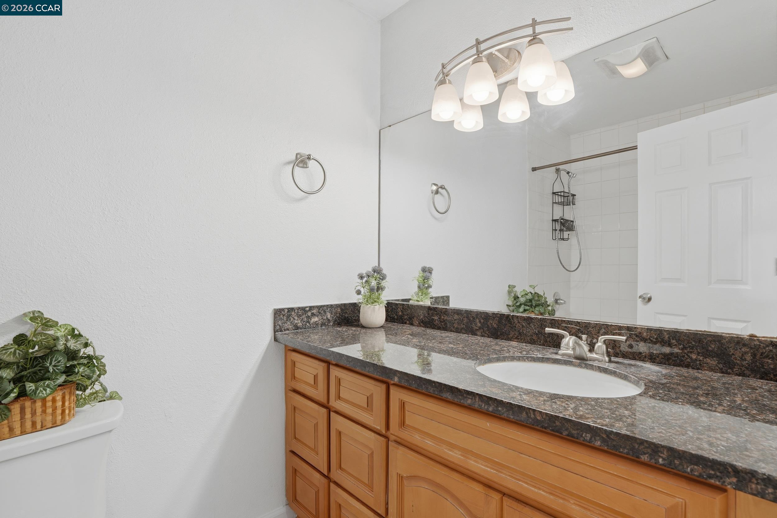 1591 Ellis Street, Unit 307 Concord, CA 94520 - Photo 11 of 13 a bathroom with a granite countertop sink and a mirror