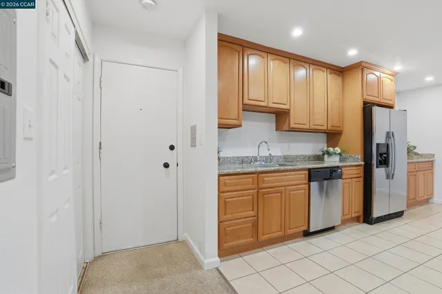 a kitchen with stainless steel appliances granite countertop a refrigerator and a sink