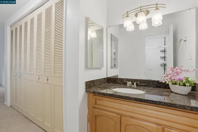 a bathroom with a granite countertop sink a vanity and a mirror