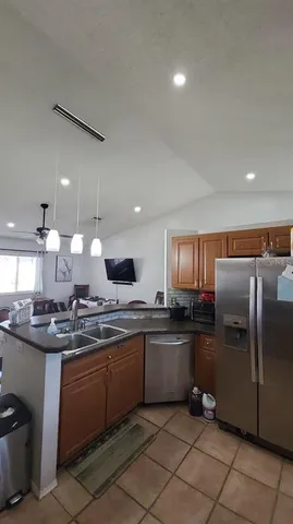 a kitchen with stainless steel appliances granite countertop a sink counter space cabinets and a refrigerator