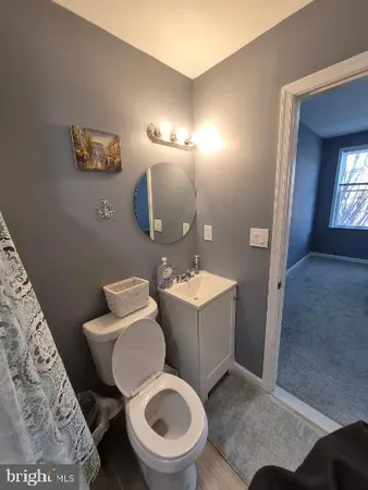 a bathroom with a toilet and a mirror