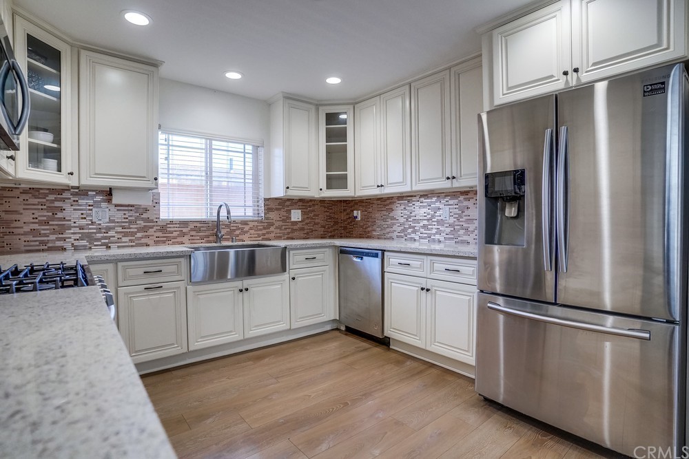 9559 Firestone Boulevard, Unit D Downey, CA 90241 - Photo 13 of 24 a kitchen with stainless steel appliances granite countertop a refrigerator sink and cabinets
