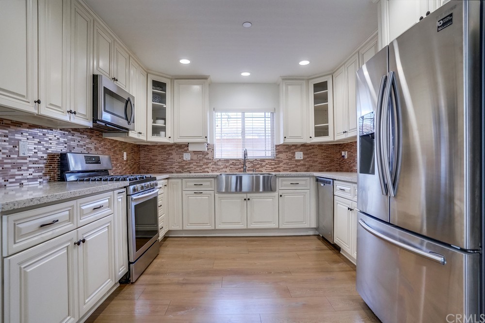 9559 Firestone Boulevard, Unit D Downey, CA 90241 - Photo 2 of 24 a kitchen with granite countertop white cabinets and stainless steel appliances