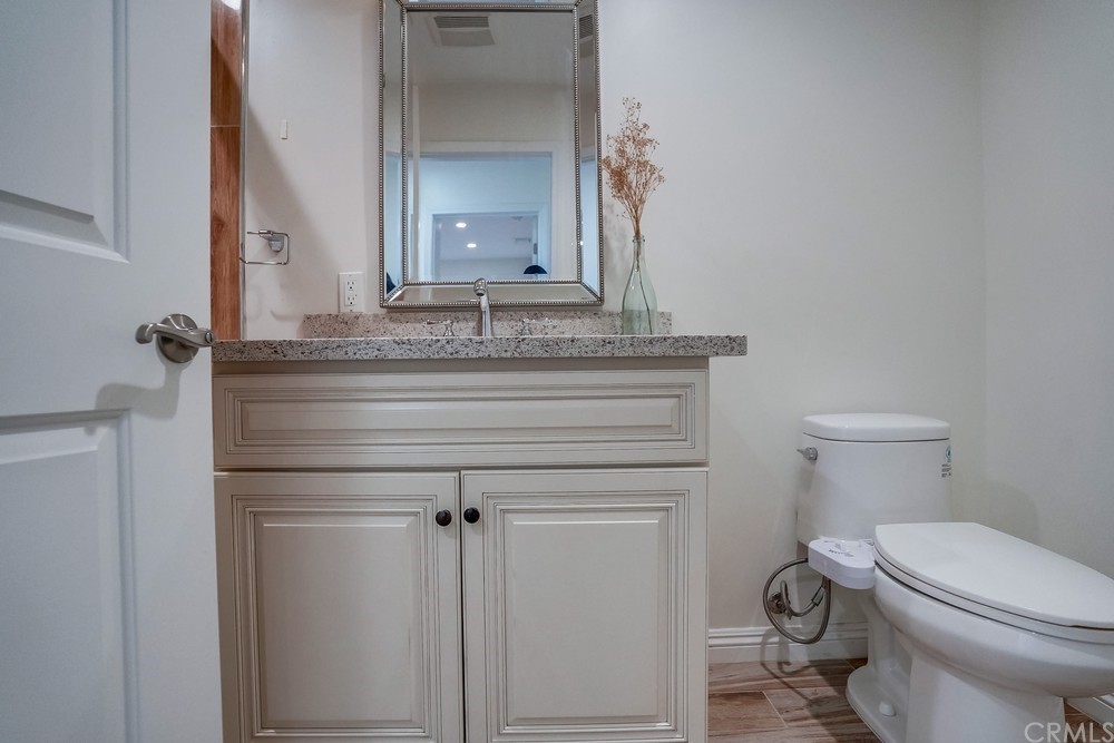 9559 Firestone Boulevard, Unit D Downey, CA 90241 - Photo 22 of 24 a bathroom with a toilet sink and mirror