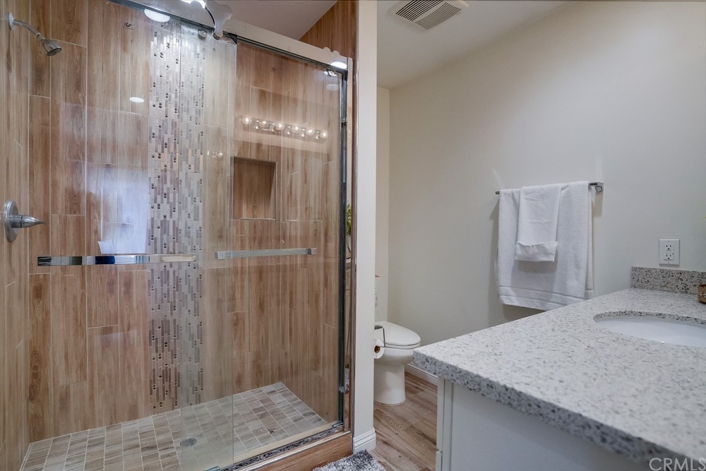 9559 Firestone Boulevard, Unit D Downey, CA 90241 - Photo 23 of 24 a bathroom with a granite countertop sink and shower