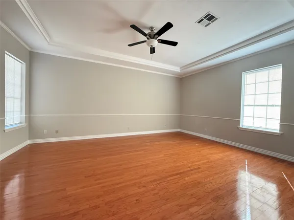 a view of an empty room with window and a kitchen