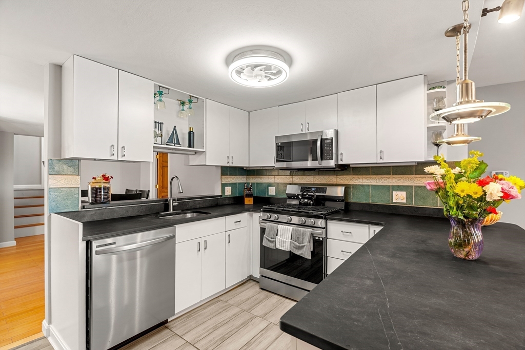 3 Adams Avenue Methuen, MA 01844 - Photo 7 of 37 a kitchen with a sink stainless steel appliances and cabinets
