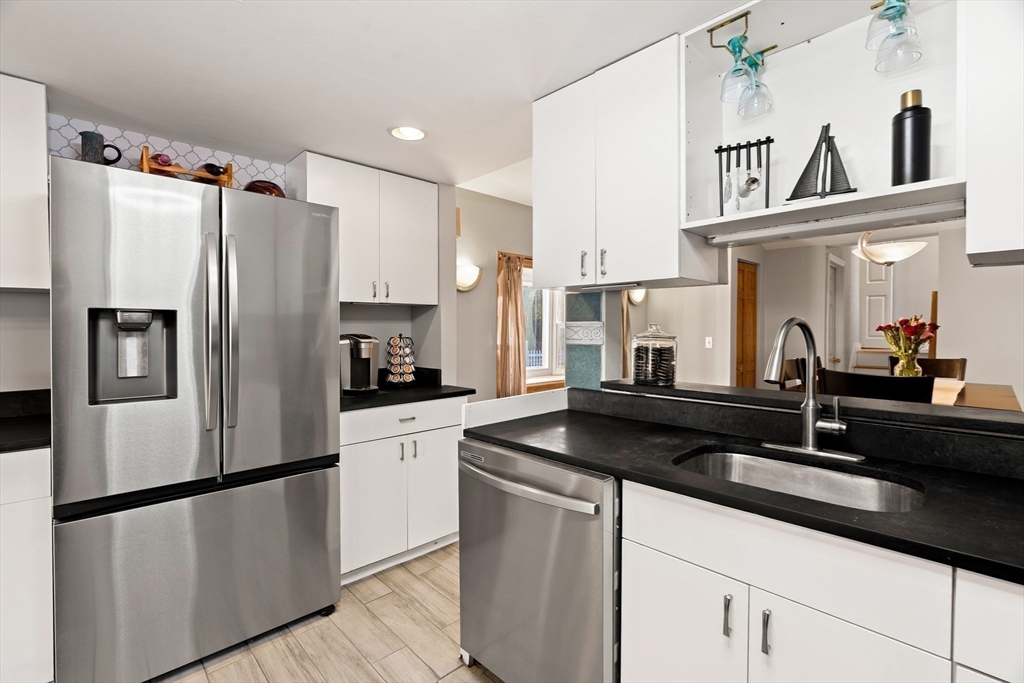 3 Adams Avenue Methuen, MA 01844 - Photo 9 of 37 a kitchen with stainless steel appliances granite countertop a refrigerator a sink and white cabinets
