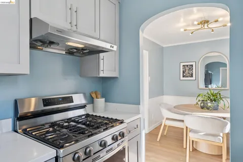 a kitchen with a stove a table and cabinets