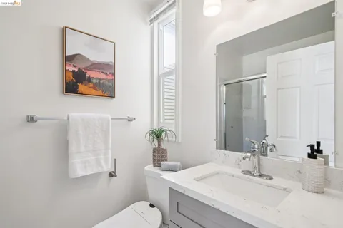 a bathroom with a granite countertop sink a toilet and a mirror